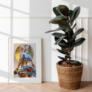 K&ouml;nnte beinhalten: Ein gerahmter Kunstdruck zeigt eine Figur mit wei&szlig;em Haar in einem blau-goldenen Outfit, die ein Schwert vor einem goldenen kreisf&ouml;rmigen Hintergrund h&auml;lt. Neben dem Rahmen steht ein hoher Gummibaum mit dunkelgr&uuml;nen Bl&auml;ttern in einem Weidenkorb.