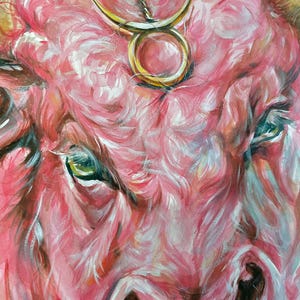 Puede incluir: Una pintura expresiva de la cara de un toro en tonos rosa, blanco y rojo. Un s&iacute;mbolo del zodiaco Tauro de color dorado est&aacute; colocado en la frente del toro. El texto www.karamfila.studio est&aacute; impreso en la esquina inferior derecha.