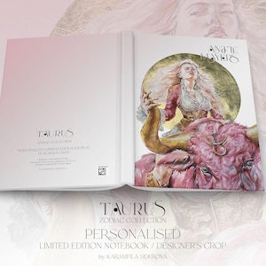 May include: A hardcover journal featuring a Taurus zodiac theme. The cover displays a pink bull and a woman with long hair against a gold circle. Text includes Taurus Zodiac Collection, Personalized Limited Edition Notebook, and Designer's Crop.