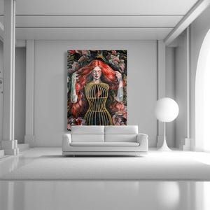 Op de afbeelding: Een rechthoekige wandkunstprint met een persoon met lang, golvend rood haar, gekleed in een goudkleurig kooivormig lijfje, omringd door donkere, textuurrijke florale elementen. Het kunstwerk hangt aan een muur boven een witte bank.