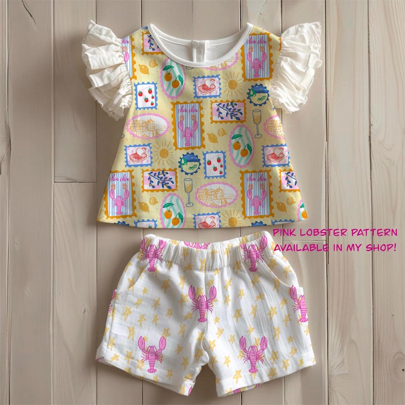 Pu&ograve; includere: Un completo per bambini composto da un top giallo con scollo bianco e maniche a balze, decorato con motivi a francobollo. Gli shorts coordinati sono bianchi con motivi di aragoste rosa e stelle gialle. Il testo "PINK LOBSTER PATTERN AVAILABLE IN MY SHOP!" &egrave; visibile.