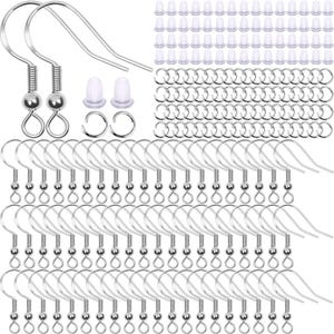 May include: A collection of silver-toned metal earring hooks featuring a coiled spring and a small bead detail, accompanied by numerous clear silicone earring backs and small circular metal jump rings for jewelry making and crafting projects.