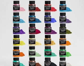 May include: A collection of twenty small plastic jars filled with various colored mica powder pigments. Each jar features a black cap and a label reading Mica Powder Pigments. Beside each jar is a small pile of the corresponding colored powder.