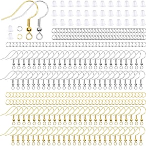 May include: A jewelry making kit containing gold and silver tone earring hooks, small metal jump rings, and clear silicone earring backs. The set includes numerous individual components arranged in rows for crafting earrings and jewelry pieces.