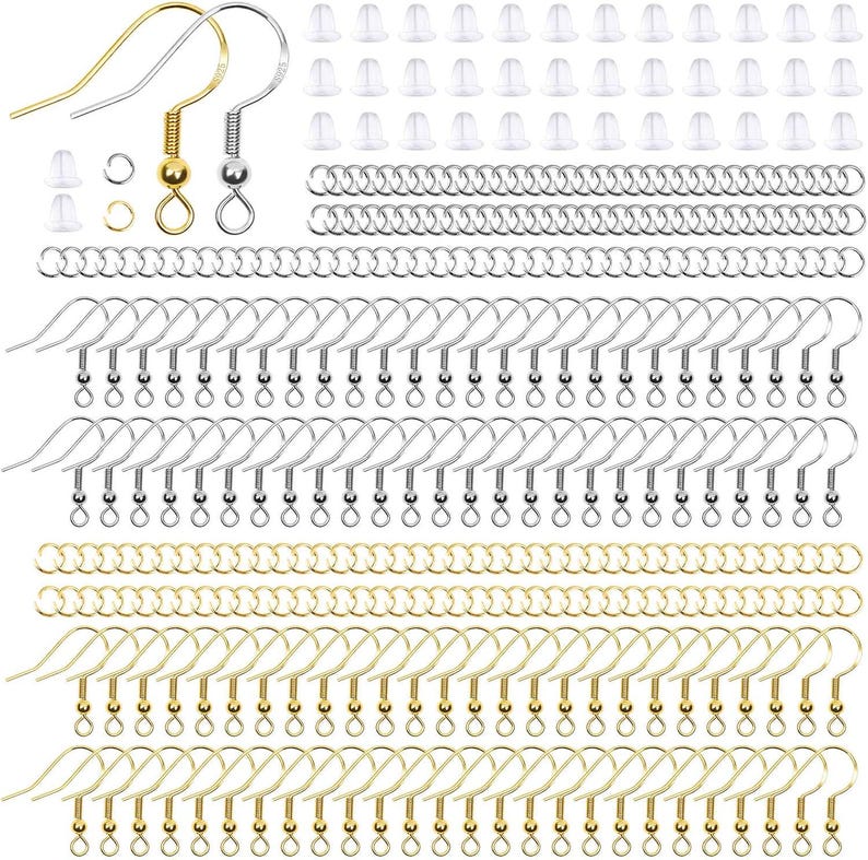 May include: A jewelry making kit containing gold and silver tone earring hooks, small metal jump rings, and clear silicone earring backs. The set includes numerous individual components arranged in rows for crafting earrings and jewelry pieces.