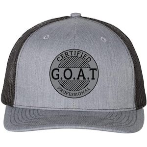 May include: A gray and black trucker hat with a black embroidered patch that says "CERTIFIED G.O.A.T. PROFESSIONAL".