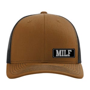 May include: A brown trucker hat with a black mesh back. The hat features the word "MILF" in white block letters on a black rectangular patch on the front.