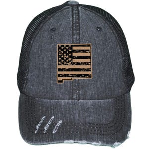 May include: A black distressed denim trucker hat with a mesh back. The hat features a brown distressed American flag design in the shape of the state of New Mexico.