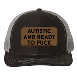 May include: Black and gray trucker hat with a brown rectangular patch. The patch features the text "AUTISTIC AND READY TO FUCK" in white capital letters. The hat has a mesh back and a curved brim.