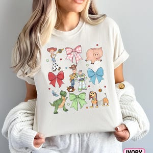 a woman holding a pillow with cartoon characters on it