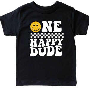 A black t-shirt with a yellow smiley face and the text "ONE HAPPY DUDE" printed on it.