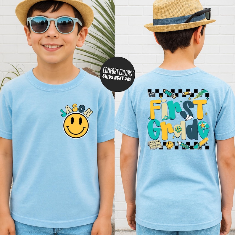 A young boy wearing a blue t-shirt with a smiley face and the name "JASON" printed on it, along with a straw hat and sunglasses.