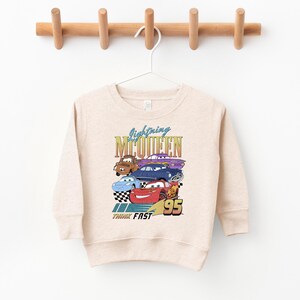 a white sweatshirt hanging on a wooden hanger