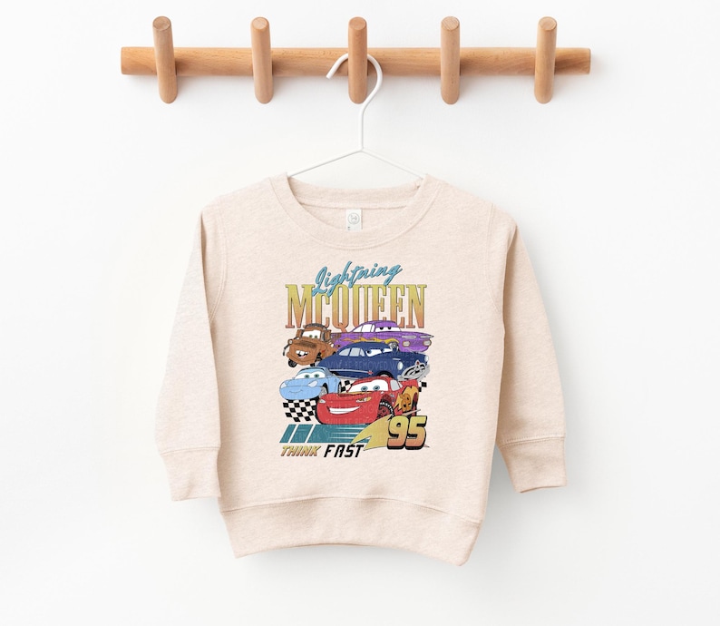 a white sweatshirt hanging on a wooden hanger