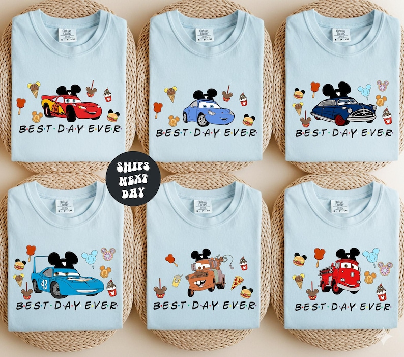 six identical light blue t-shirts with the phrase "BEST DAY EVER" printed on them, featuring various Disney characters and vehicles.