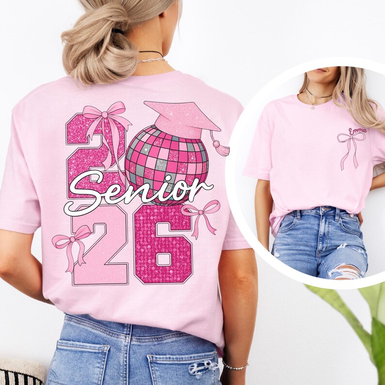 A woman wearing a pink t-shirt with a graphic design on the back, including a graduation cap, a disco ball, and the text "26 Senior".