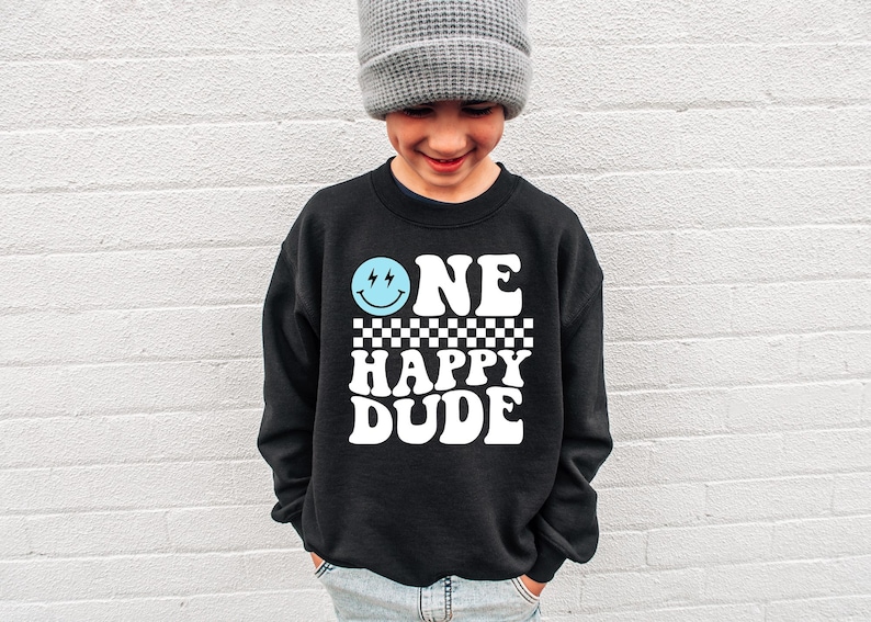 a young boy wearing a one happy dude sweatshirt