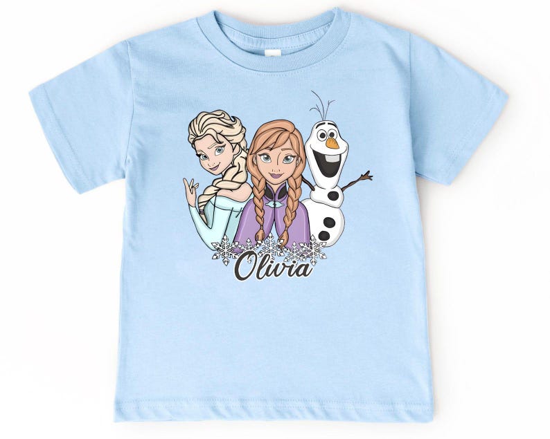 A light blue t-shirt with a graphic design featuring two cartoon girls and a snowman.