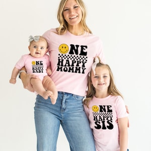 a woman and two children wearing matching shirts