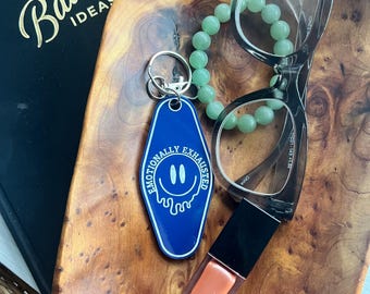 Llavero acrílico inspirado en un motel y emocionalmente agotado