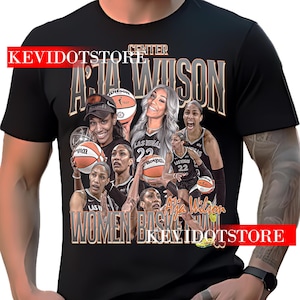 May include: Black t-shirt featuring a graphic of A'ja Wilson, a basketball player, with the text "A'ja Wilson" and "Women Basketball". The design includes images of Wilson and basketballs. The shirt also has the text "Las Vegas 22".