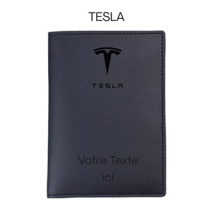 Könnte beinhalten: Ein dunkelblaues Lederportemonnaie mit dem Tesla-Logo und -Text. Das Portemonnaie trägt das Wort "TESLA" oben und unten auf dem Logo. Auf der Unterseite des Portemonnaies steht der Text "Votre Texte ici".