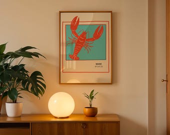 May include: A framed art print featuring a red lobster illustration on a teal background, with the word "MAINE" and a code. The print hangs above a wooden cabinet with a glowing orb lamp and potted plants.