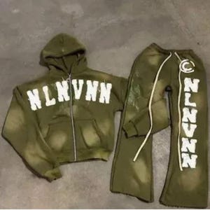Könnte beinhalten: Ein grüner Kapuzenpullover und eine passende Jogginghose mit einem weißen "NLNVNN" Grafikdruck. Der Pullover hat einen Reißverschluss.