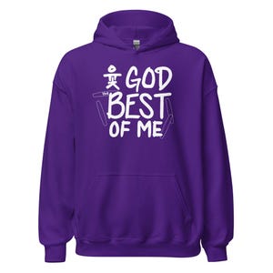 May include: A purple hooded sweatshirt with the text "GOD BEST OF ME" in white. The design includes a stylized symbol above the word "GOD". The sweatshirt has a front pocket and a drawstring hood.
