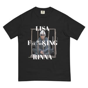 May include: Black t-shirt with the text "LISA F@%&ING RINNA" in white. The graphic features a person behind bars. The shirt is made of a soft, comfortable material.
