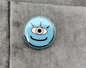Blå enögd smiley-knappnål: Udda utomjordisk accessoar