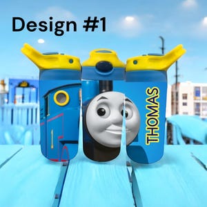 May include: Three blue water bottles with yellow lids and the image of Thomas the Tank Engine. The word "THOMAS" is printed vertically on one bottle. The text "Design #1" is at the top of the image.