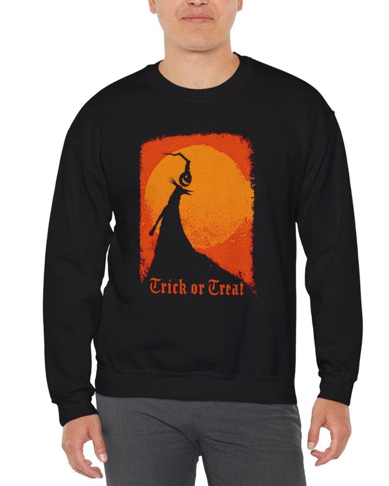 May include: A black long-sleeve sweatshirt featuring a graphic print of a silhouette figure standing on a hill against a large orange moon. Above the figure is a hanging jack-o'-lantern. The text "Trick or Treat" is printed in orange below.