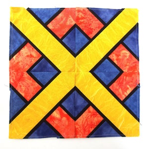 May include: A quilt block with a geometric pattern in red, yellow, and blue. The block is made up of squares and rectangles, and the colors are arranged in a symmetrical pattern.