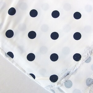 May include: White fabric with a repeating pattern of dark blue polka dots.