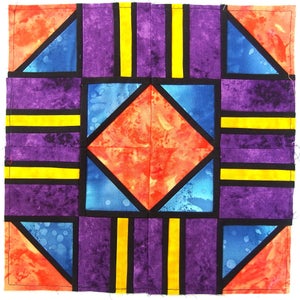 May include: A quilt block with a geometric design featuring orange, blue, purple, yellow, and black fabric. The block is made up of squares, triangles, and rectangles.