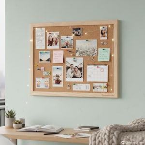 Può includere: Una bacheca rettangolare con una cornice in legno chiaro espone foto, appunti e un calendario. La bacheca è adornata con puntine, luci di fata e piccoli oggetti decorativi. Lo sfondo è una parete azzurra.