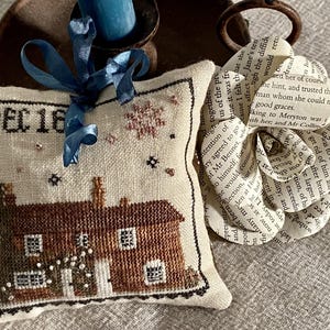 Cojín de punto de cruz con la casa de Jane Austen y patrón en PDF para la técnica de patchwork inglés.
