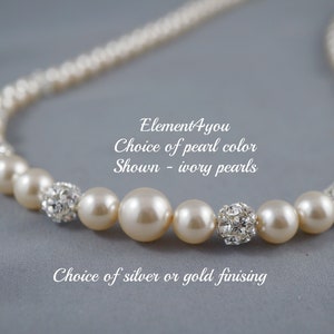 May include: A pearl necklace with ivory pearls and crystal accents. The necklace is available in silver or gold finishes. "Element4you Choice of pearl color Shown - ivory pearls Choice of silver or gold finishing"