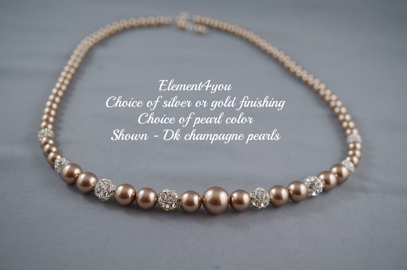 May include: A brown pearl necklace with silver or gold accents. The necklace is made with champagne colored pearls and has a choice of silver or gold finishing.  Element4you.