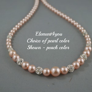May include: A peach-colored pearl necklace with silver rhinestone accents.  Element4you Choice of pearl color Shown - peach color