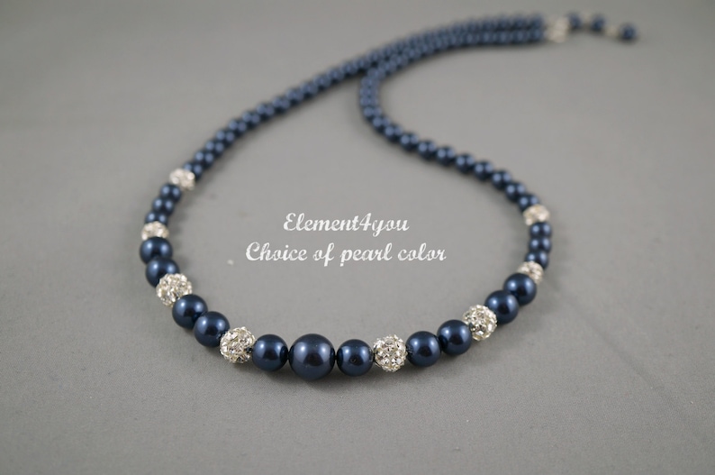 May include: A navy blue pearl necklace with silver rhinestone accents. The necklace is made of round pearls and silver beads with rhinestones.