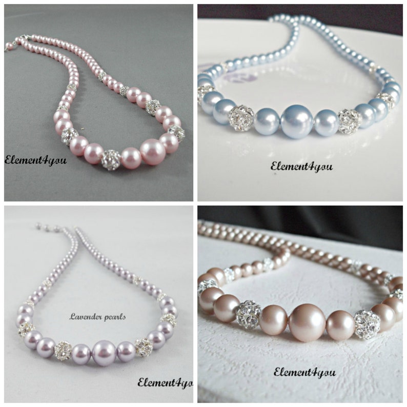 May include: Four necklaces with pearl beads and rhinestone accents. The necklaces are in four different colors: pink, light blue, lavender, and light brown.
