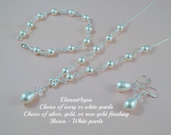 May include: A jewelry set consisting of a necklace, a bracelet, and drop earrings featuring white pearls and clear crystals on a silver-toned chain. Text reads: Element4you, Choice of ivory or white pearls, Choice of silver, gold, or rose gold finishing, Shown - White pearls.