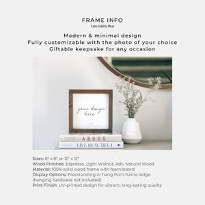 Puede incluir: Un marco de madera cuadrado con el texto "your design here" sobre un fondo blanco. El marco se muestra sobre una pila de libros, con un jarr&oacute;n de flores y un espejo en el fondo. El marco est&aacute; disponible en tama&ntilde;os de 20 cm x 20 cm o 30 cm x 30 cm.