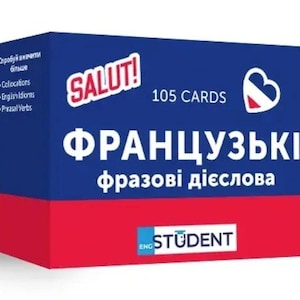 May include: A blue and red box of flashcards for learning French. The box has the word "SALUT!" in red, the text "105 CARDS", and the words "ФРАНЦУЗЬКІ фразові дієслова" in white. The box also has the text "ENG STUDENT".