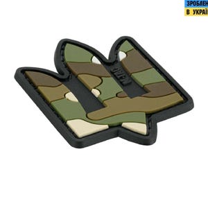 Könnte beinhalten: Ein gestickter Patch in Tarnfarben Schwarz und Grün mit dem ukrainischen Dreizack. Der Patch ist aus Stoff und hat einen schwarzen Rand.
