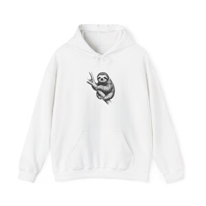 May include: White hooded sweatshirt with a kangaroo pocket and drawstring. The front features a black and white illustration of a sloth clinging to a branch. A casual, comfortable garment for everyday wear.