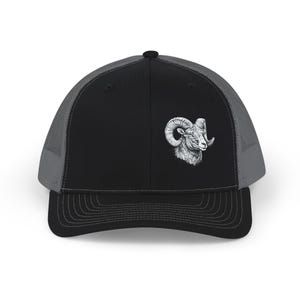 May include: Black and gray trucker hat featuring a white illustration of a ram's head on the front. The hat has a curved brim and a mesh back for breathability. A classic accessory for outdoor enthusiasts.