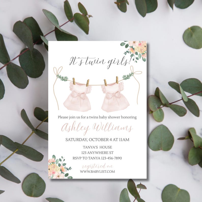 May include: A baby shower invitation with the text "It's twin girls!" features two pink dresses hanging on a clothesline. The invitation includes details for Ashley Williams' baby shower, including the date, time, and location.